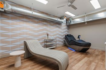 A room with a massage chair and a table.